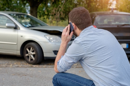 man making a phone call after a car accident